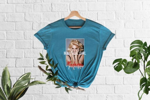 Step into the glamour and attitude of the 80s with the Madonna Material Girl Shirt, a tribute to the iconic pop sensation's hit song and signature style. Crafted from comfortable and high-quality fabric, this shirt embodies the essence of Madonna's rebellious spirit and fashion-forward sensibilities.