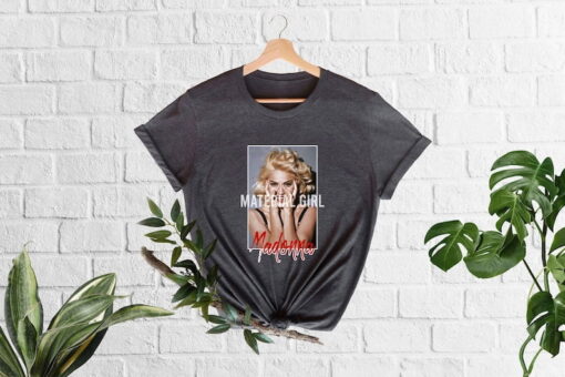 Step into the glamour and attitude of the 80s with the Madonna Material Girl Shirt, a tribute to the iconic pop sensation's hit song and signature style. Crafted from comfortable and high-quality fabric, this shirt embodies the essence of Madonna's rebellious spirit and fashion-forward sensibilities.